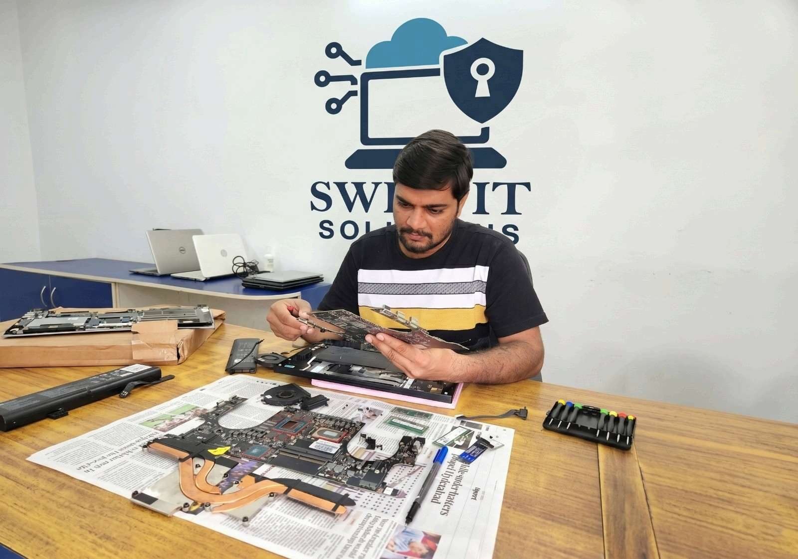 SwiftIT Solutions technician fixing a laptop at a customer's home in Hyderabad